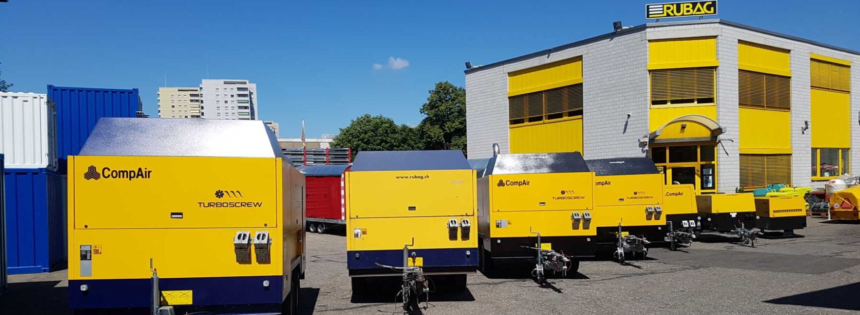 Mehrere Compair Kompressoren in Reih und Glied vor dem RUBAG Hauptsitz